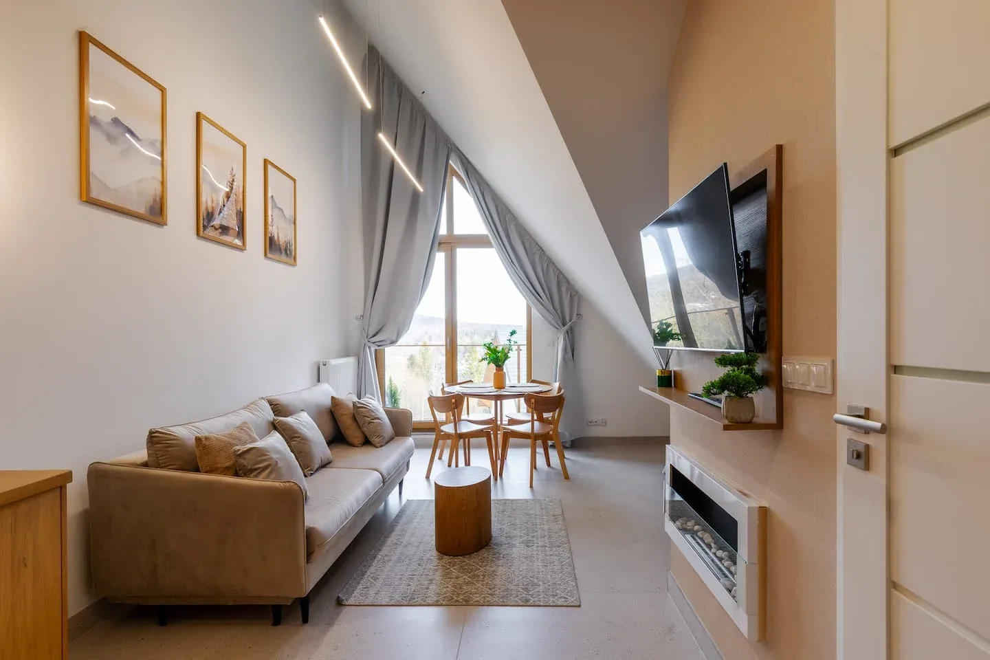 Obývací pokoj Mariental pod šikmou střechou se vstupem na balkon