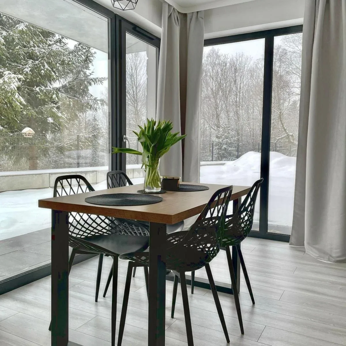 Stół przy dużym oknie w apartamencie Widok800